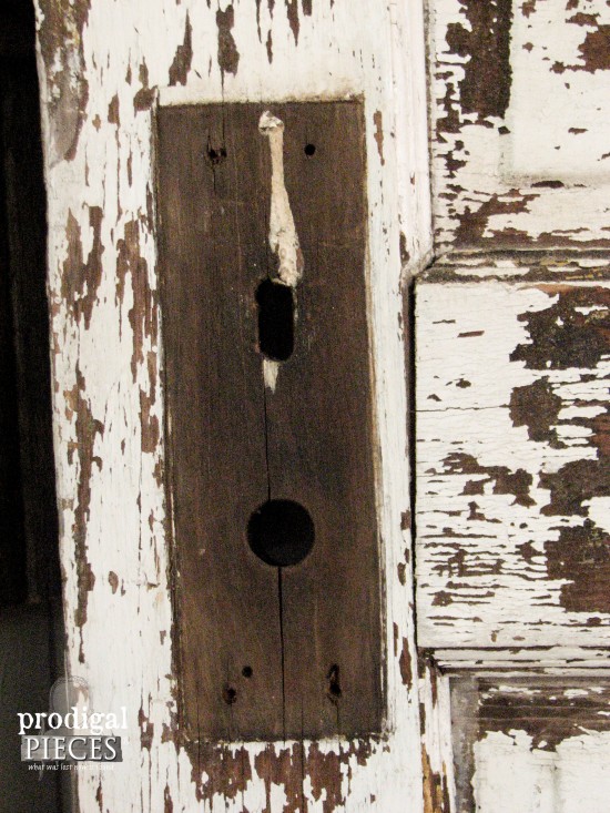 Antique chippy white door becomes functional decor with the addition of barn beam pegs by Prodigal Pieces. www.prodigalpieces.com
